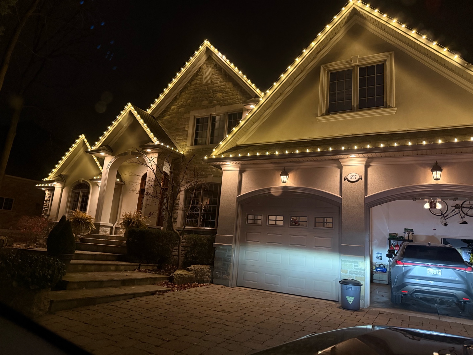 Warm white Christmas lights outlining roof peaks on a Burlington home