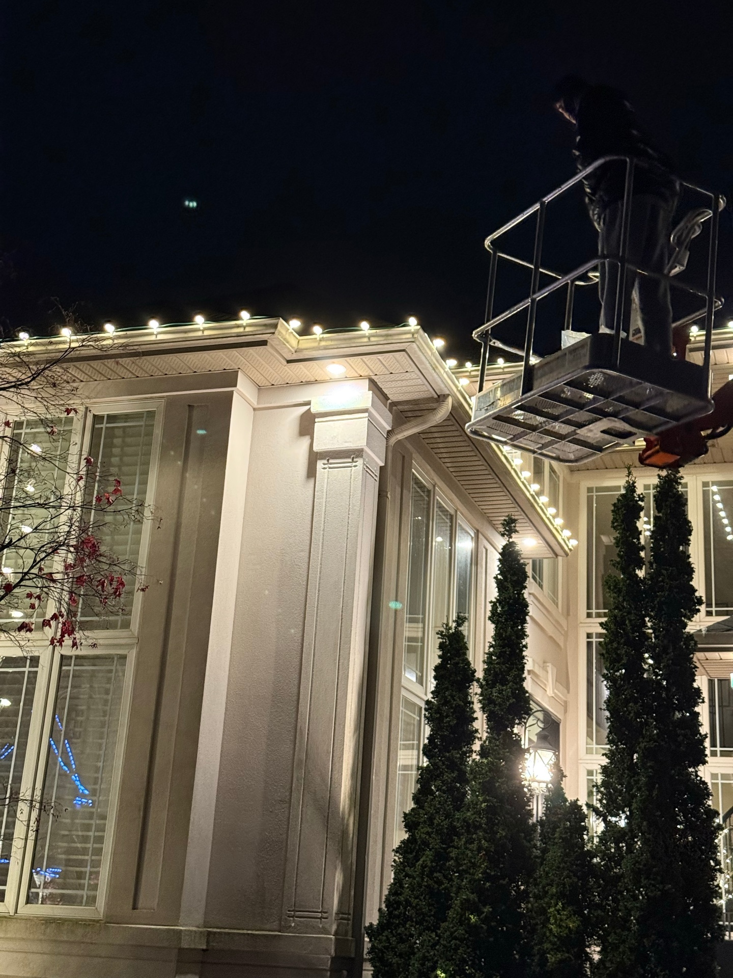 Warm white C9 Christmas lights installed on a two-storey roofline in Hamilton, Ontario